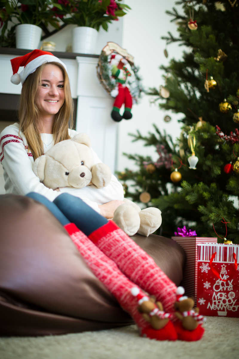 圣诞节抱着泰迪熊看向镜头微笑的女孩