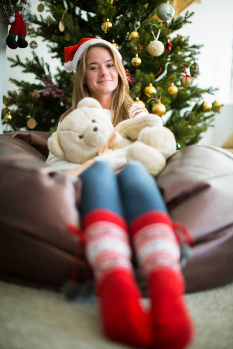 移轴镜头下抱着泰迪熊的快乐圣诞女孩