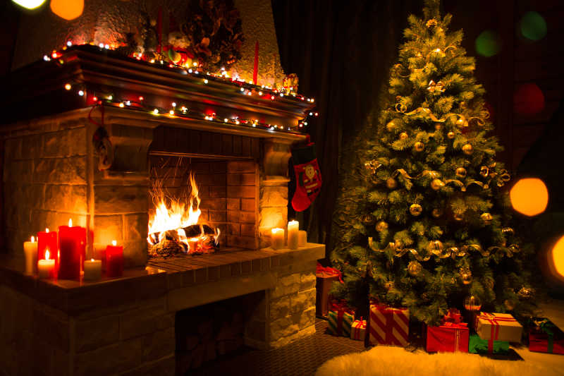 靠近燃烧的壁炉的礼物圣诞树