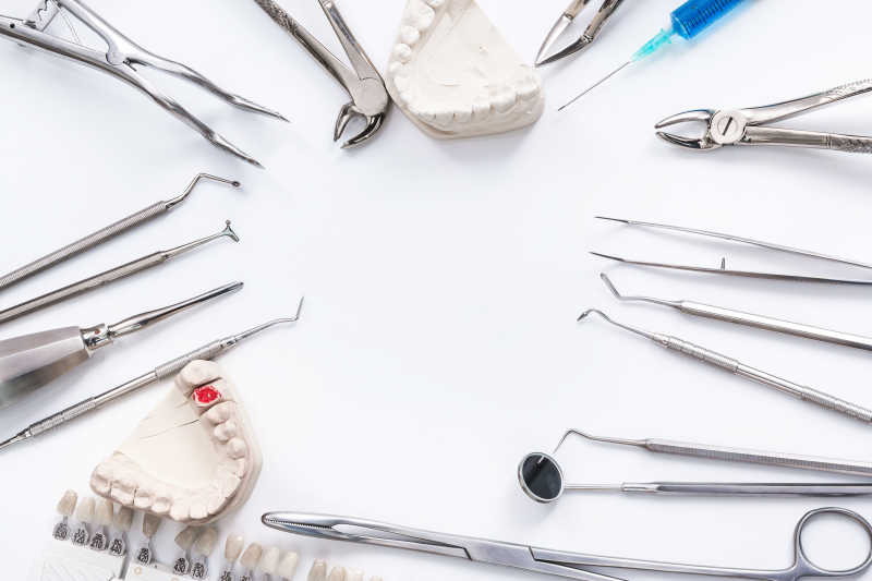 白色桌子上的牙科工具与牙齿模型