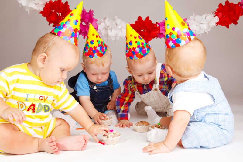 四个婴儿吃生日蛋糕