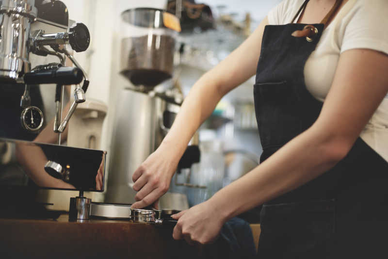女店员操作咖啡机制作咖啡