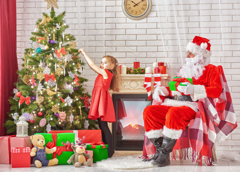 圣诞树旁的圣诞老人和小女孩
