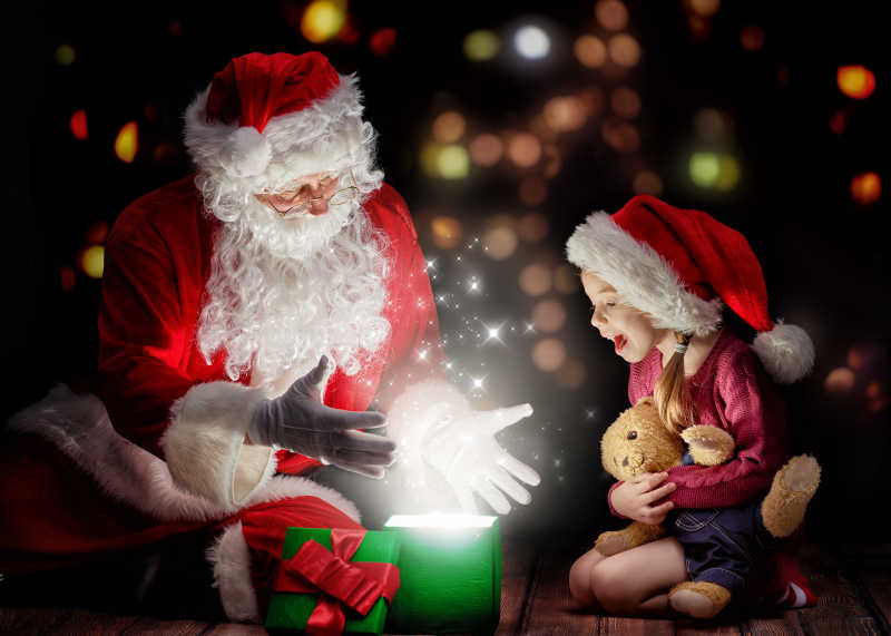 给小女孩变魔术的圣诞老人