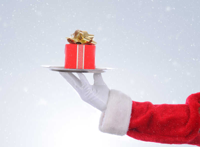 圣诞老人手里拿着一个银托盘和圣诞礼物