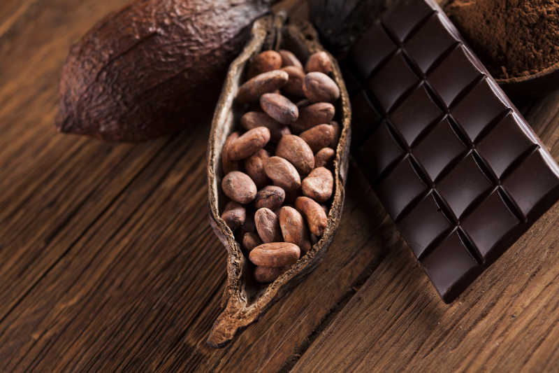木纹理桌上的巧克力和可可豆