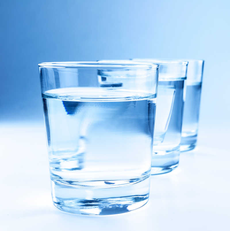 桌子上三个玻璃水杯里倒着饮用水