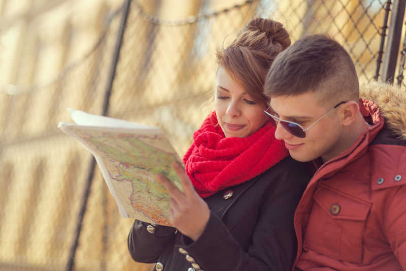户外阳光下旅行的情侣在看旅游观光地图