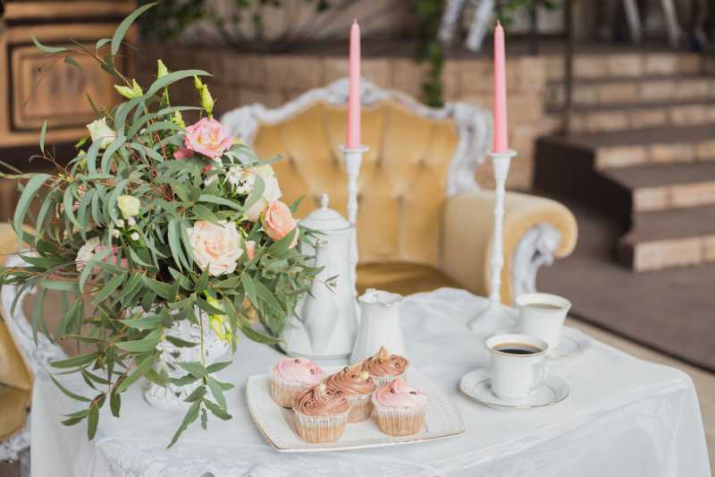 婚礼装饰区带花束和杯状蛋糕的白色桌子