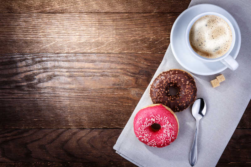 木桌上的甜甜圈和咖啡下午茶