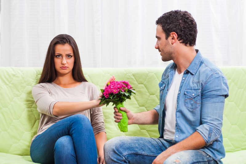沙发上女人拒绝男人递的一束花
