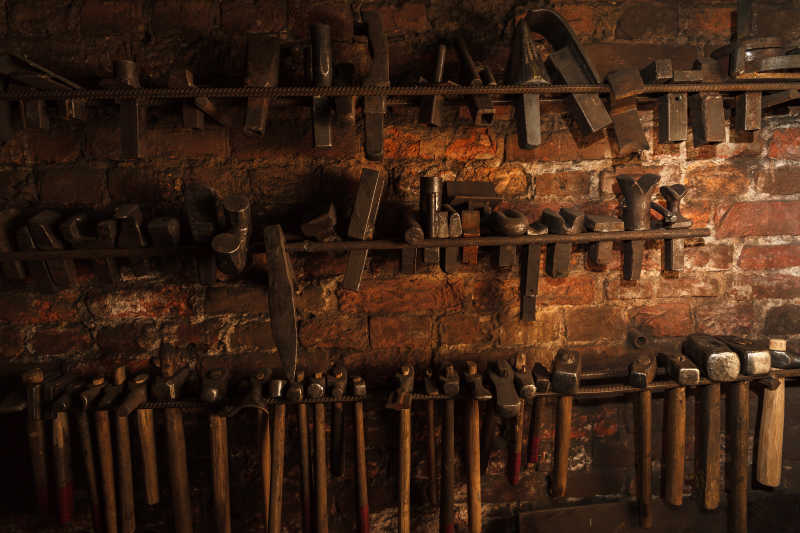旧的铁匠工具悬挂在墙面上