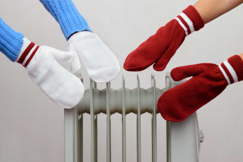 两个人戴着手套在机油冷却器旁边晒太阳