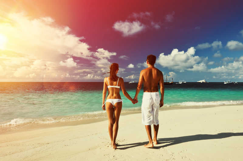 马尔代夫热带海滩上牵手的情侣
