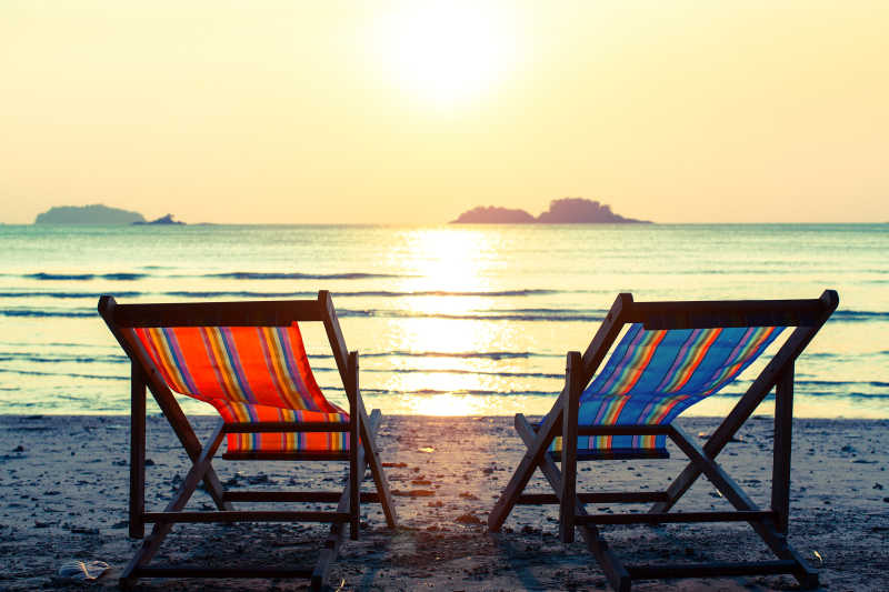 日落海滩上的两张沙滩椅