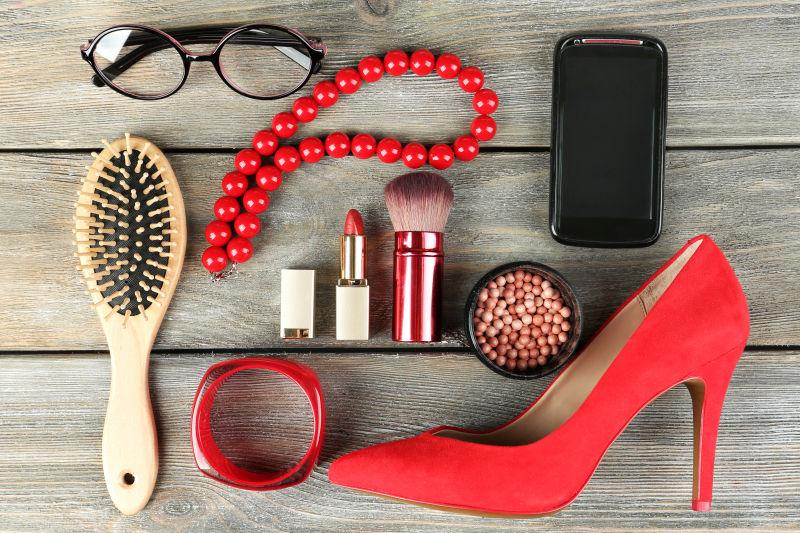 木质背景下时尚女士的红色配饰和化妆品