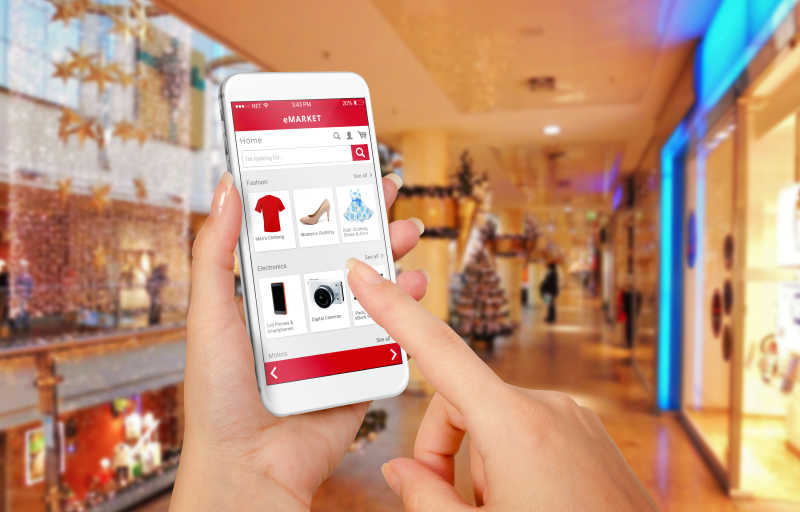 圣诞节期间智能手机在女性手中购物