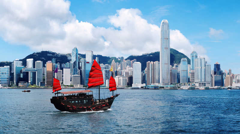 香港城市建筑前的维多利亚港上的帆船