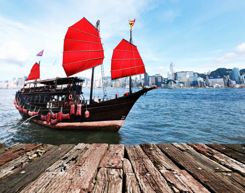香港建筑大楼背景前的红色帆船