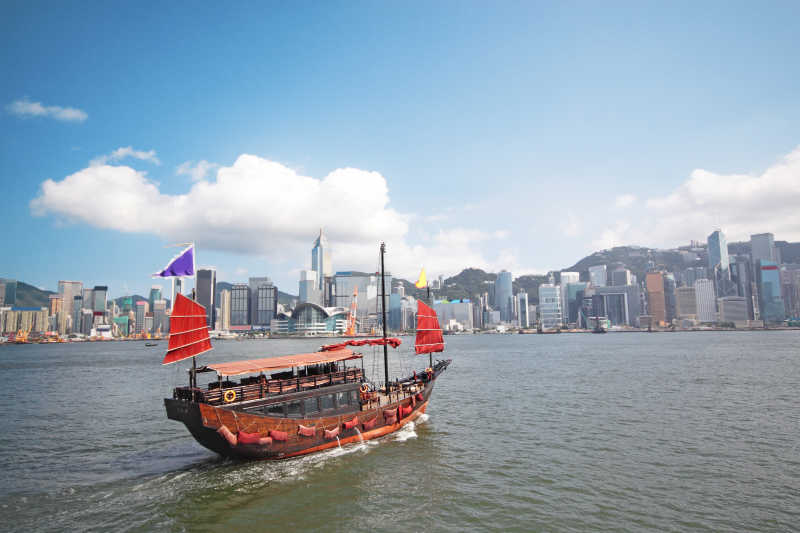 蓝天下香港维多利亚港游客红色帆船