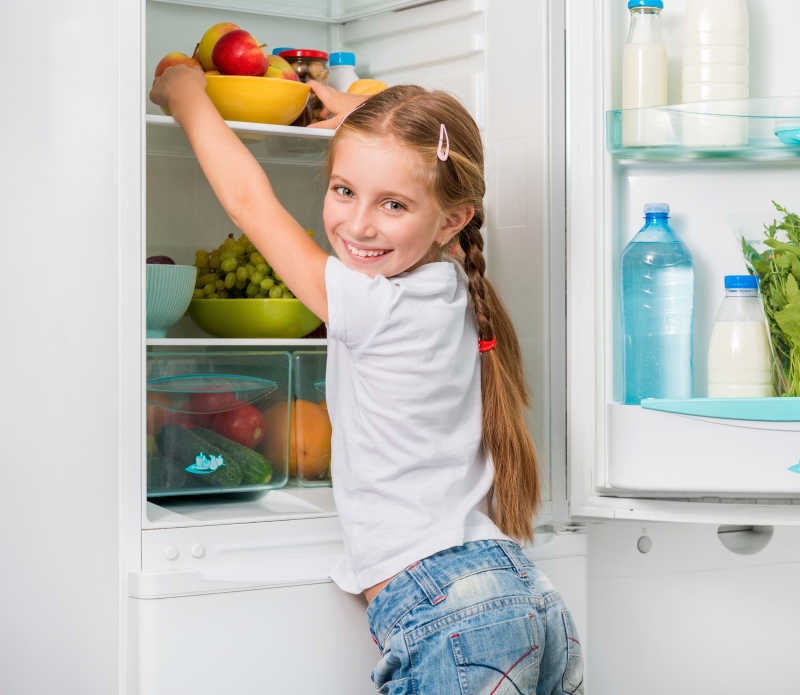 小女孩从冰箱里拿苹果