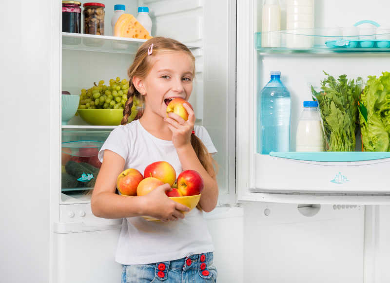 从冰箱里拿苹果的小女孩