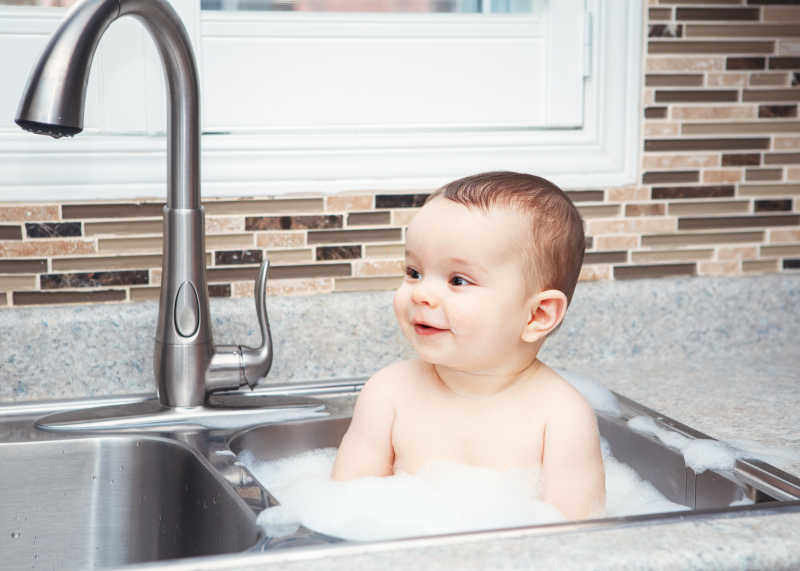 可爱的小宝贝在洗碗池里