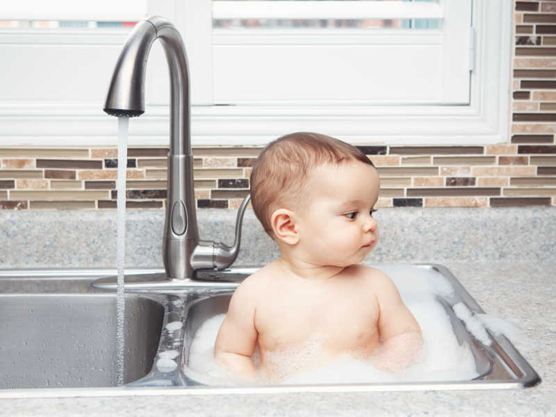 可爱的婴儿在洗碗池