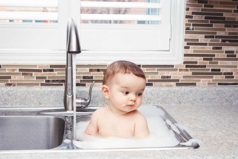 呆萌的小婴儿在洗碗池里洗澡