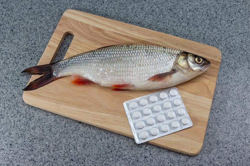 白色的鱼在切割板和药丸上