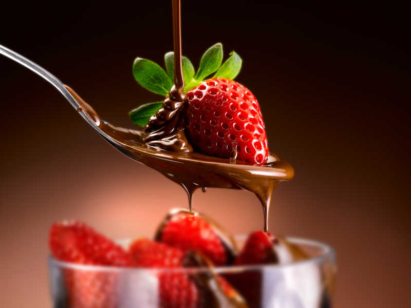 调羹里的草莓沾着巧克力
