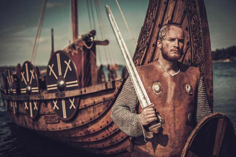 海盗船背景下手持剑和盾牌的维京勇士