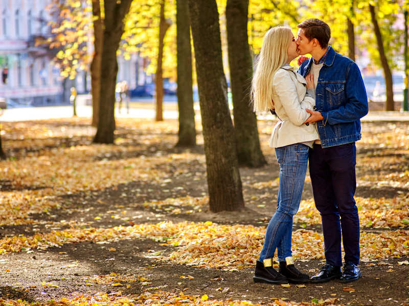 年轻夫妇在公园拥抱亲吻