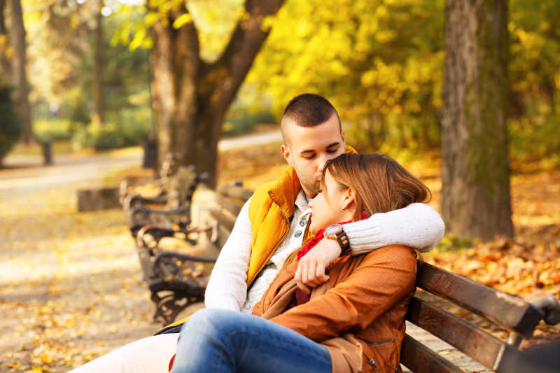 一对幸福的情侣在公园里的长椅上