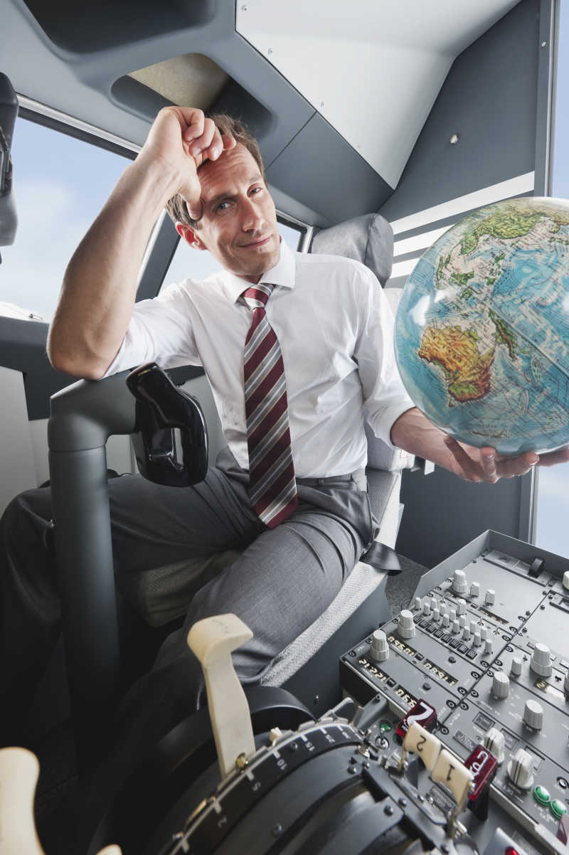 飞机上一个男人在玩着地球仪