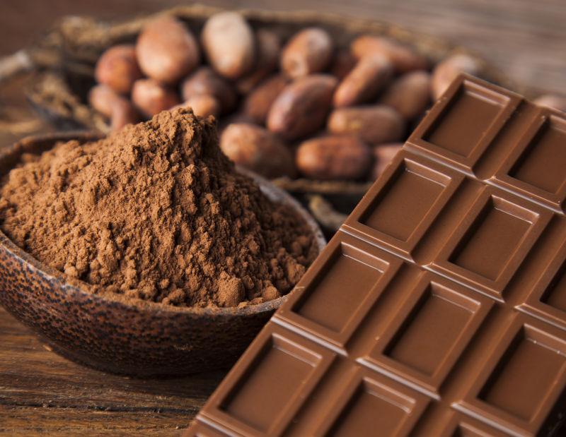 木桌上的可可粉可可豆和黑色的巧克力