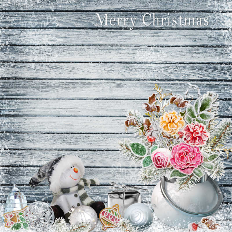灰色木板上的鲜花雪人和圣诞饰品