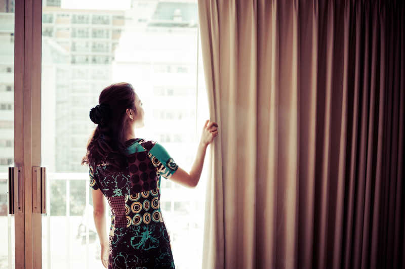 美女在阳台拉窗帘