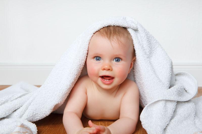 躲在白色浴巾下的可爱宝宝