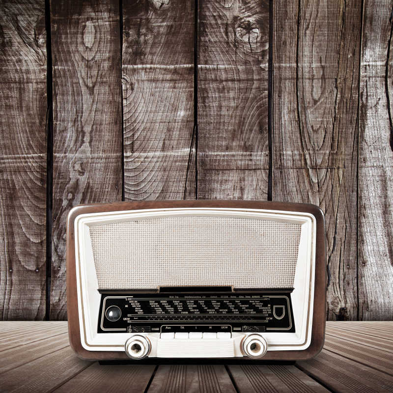 木板背景下木桌上的老式无线电收音机