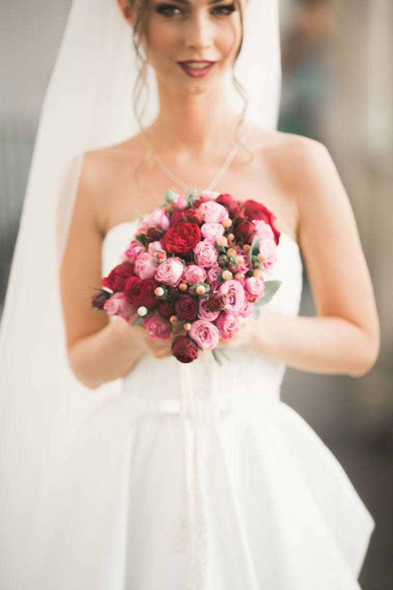 美丽的新娘拿着捧花看着镜头