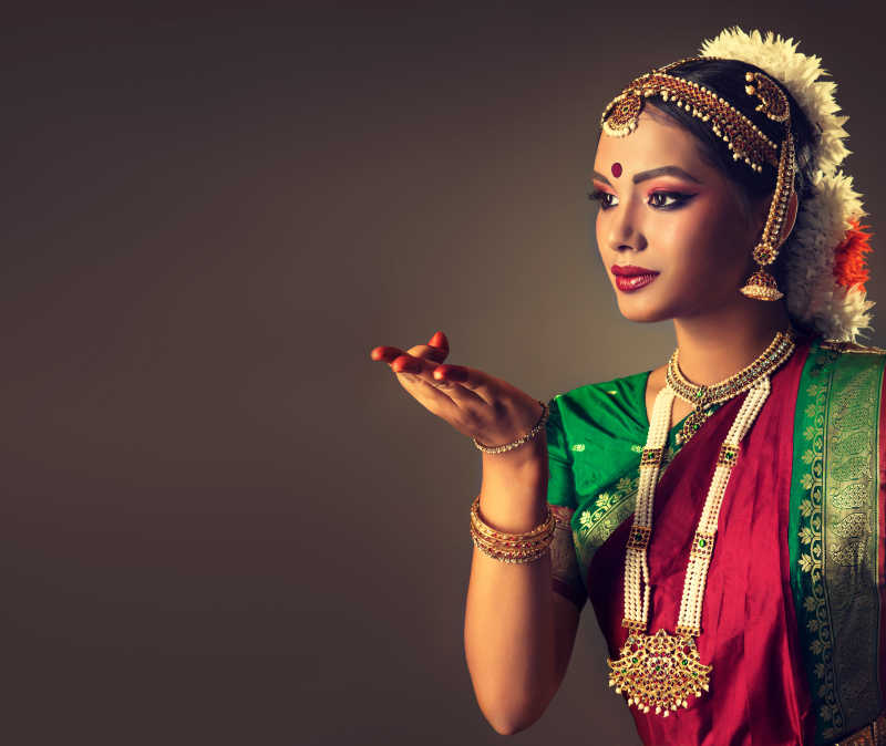 褐色背景下伸出一只手跳舞的印度舞女