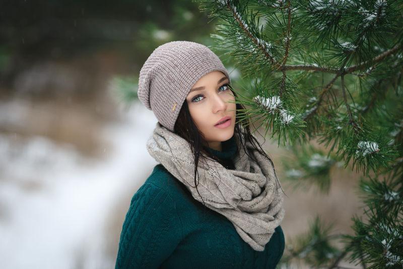 在冬季雪地里美丽的年轻女子