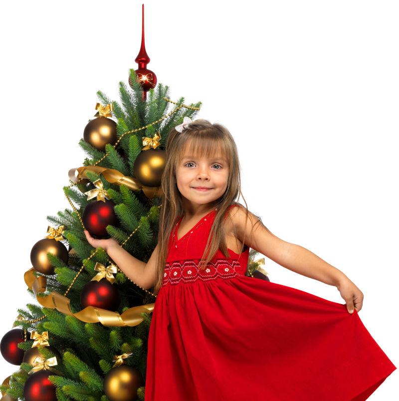 白色背景中圣诞树旁的小女孩