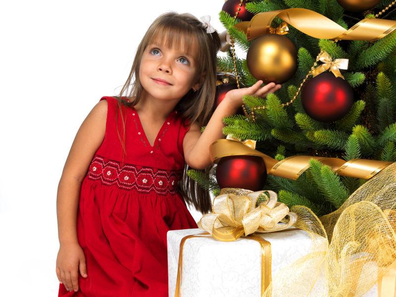 白色背景上漂亮女孩在圣诞树旁微笑着