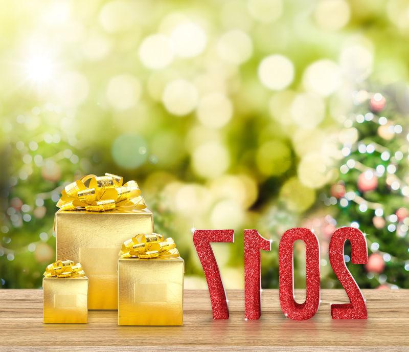 圣诞树背景下木桌上金色的新年礼物
