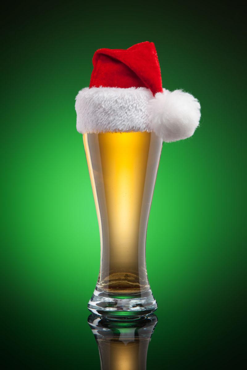 绿色背景前的圣诞啤酒杯