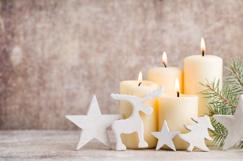 木制背景下的燃烧的白色圣诞蜡烛装饰
