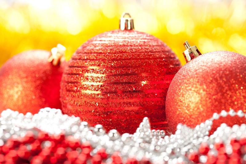 金色背景下的圣诞节的红色球和银色装饰品