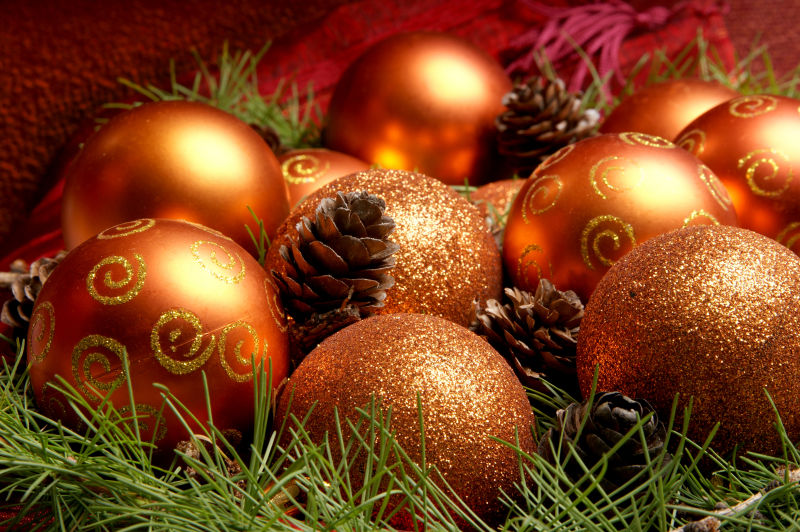 绿色圣诞树枝背景上的圣诞节的金色球状装饰品